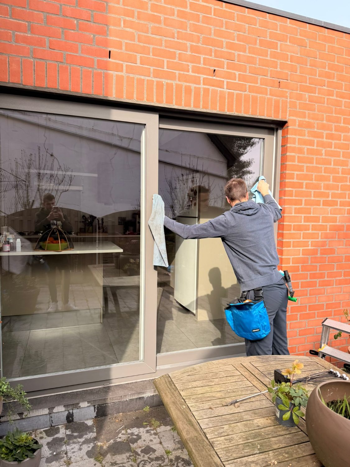 Technicien nettoyant une grande baie vitrée