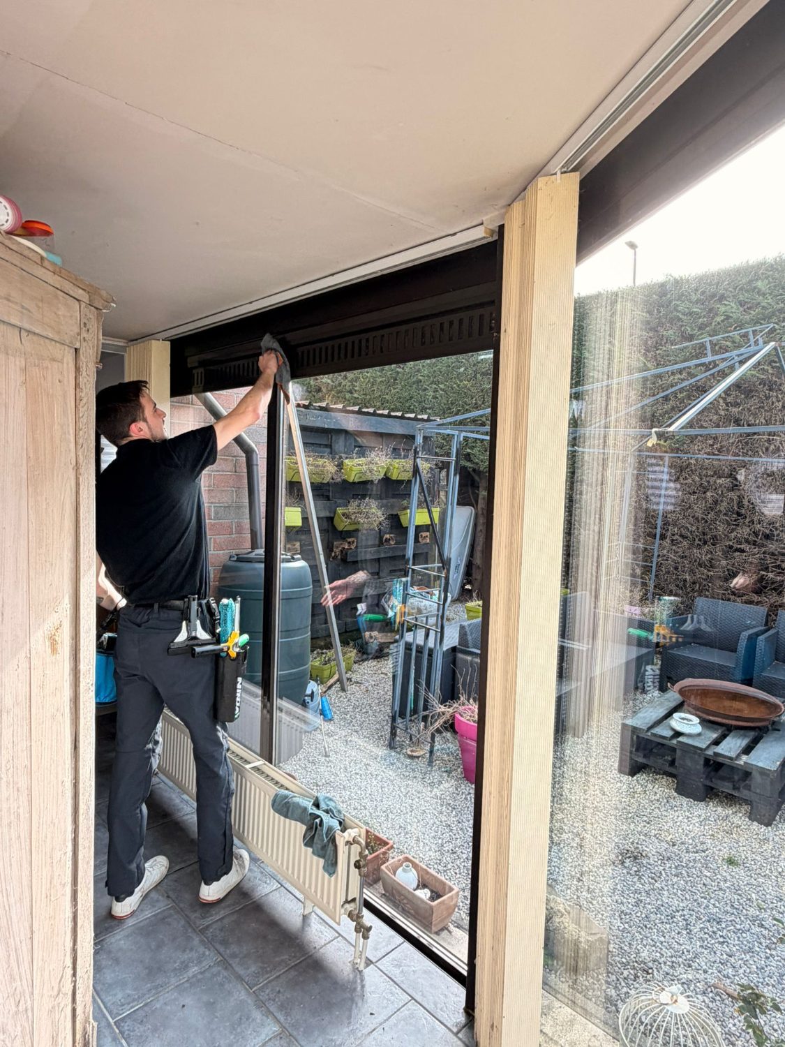Technicien nettoyant une baie vitrée depuis l'intérieur